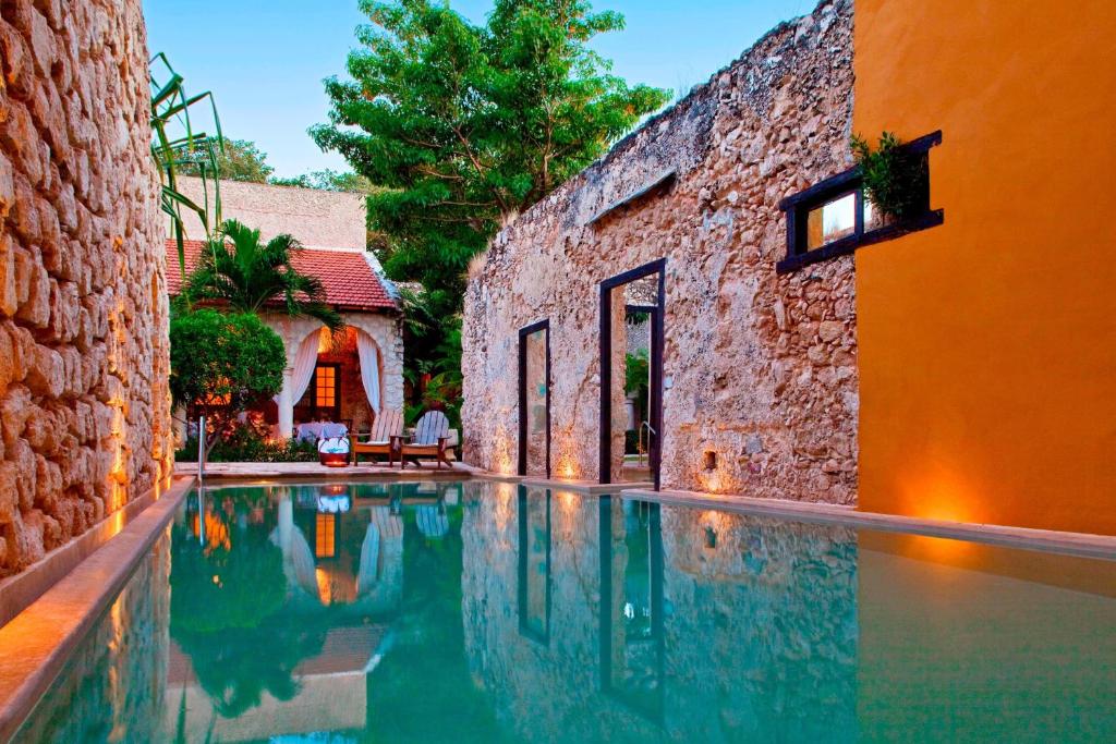 a swimming pool in front of a building at Hacienda Campeche in Campeche