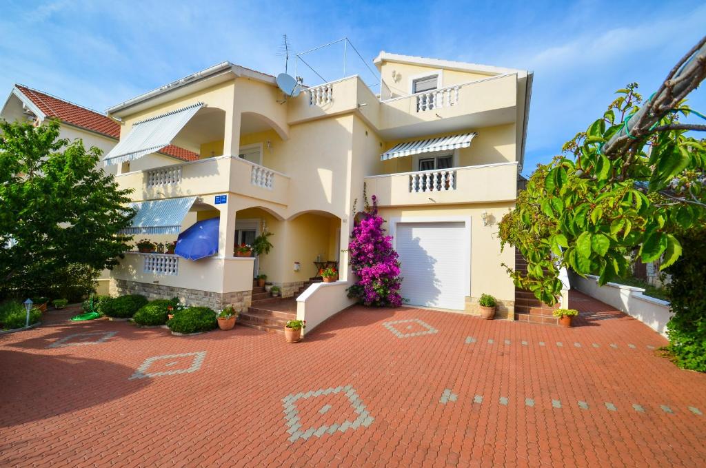 Casa blanca grande con entrada de ladrillo rojo en Apartments Veronika, en Zadar