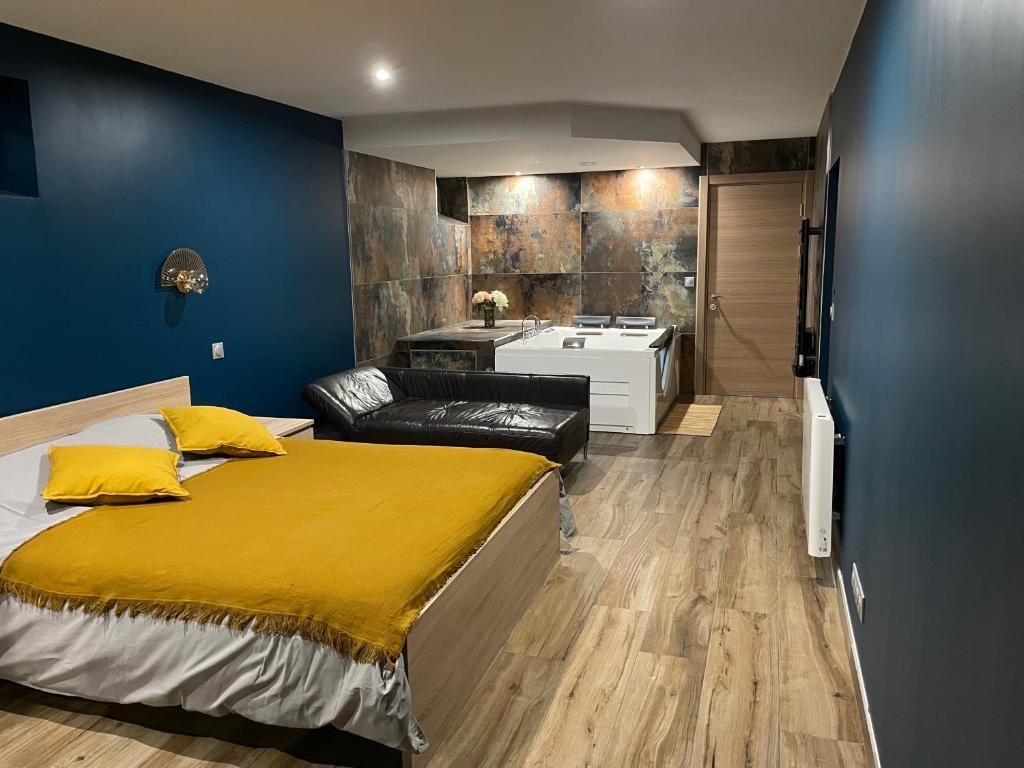 1 Schlafzimmer mit einem großen Bett und einem Badezimmer in der Unterkunft Charmant logement avec balnéo in Wintzenheim