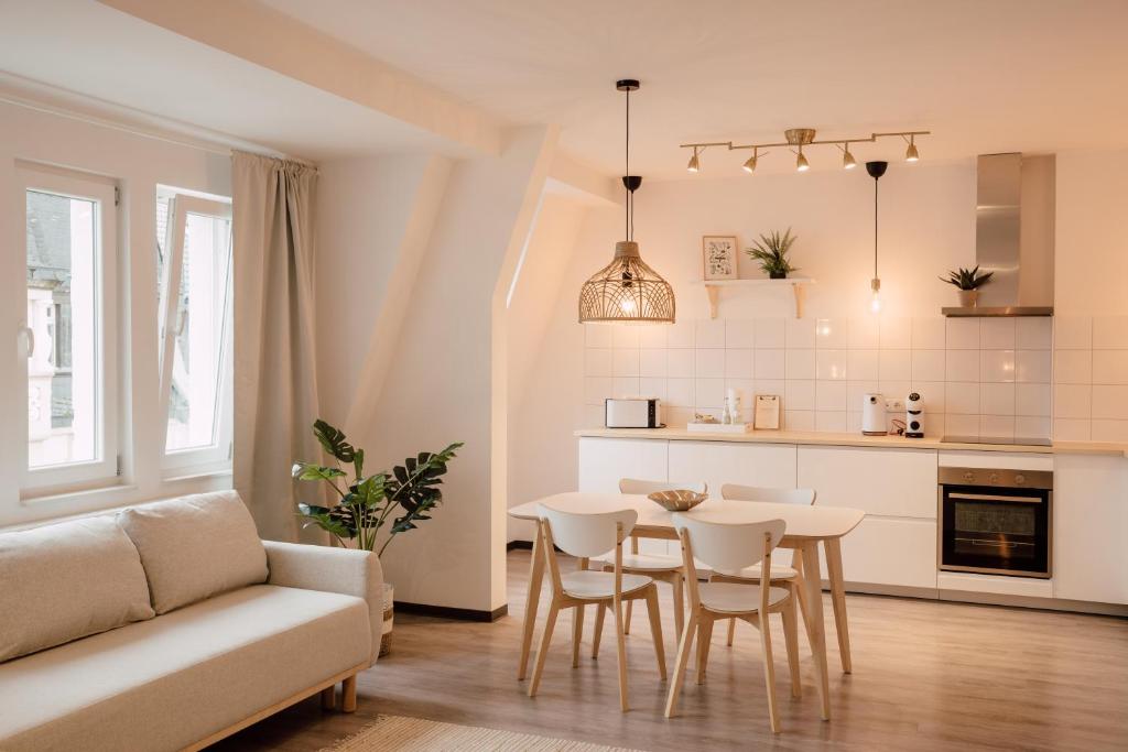 cocina y sala de estar con mesa y sillas en ZION Apartments en Neuwied