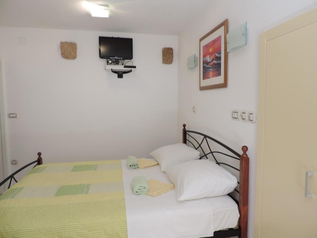 1 dormitorio con 1 cama y TV en la pared en Studio Josip, en Split