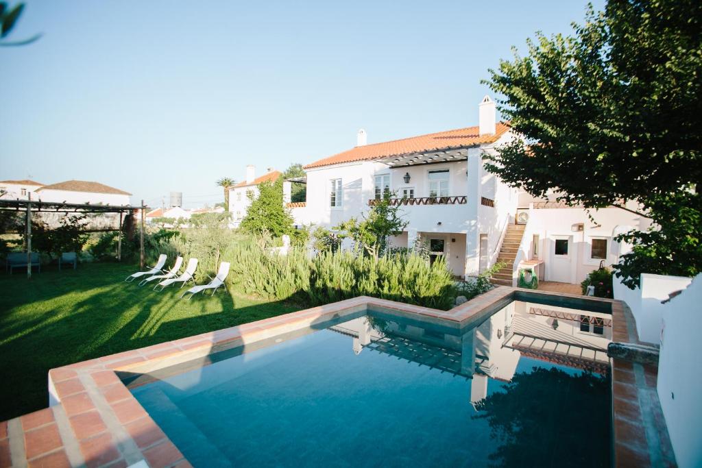 a swimming pool in front of a house at Casas da Estação, Country Houses in Marvão