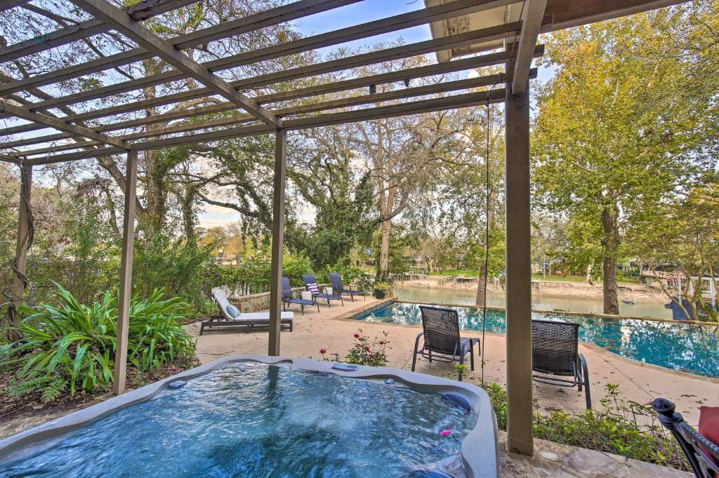 einen Whirlpool unter einer Pergola neben einem Pool in der Unterkunft 4-Season Boathouse, Hot Tub! Guadalupe River Oasis in Seguin