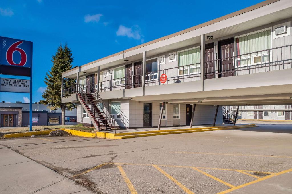 un edificio con una escalera frente a un estacionamiento en Motel 6-Fort St. John, BC, en Fort Saint John
