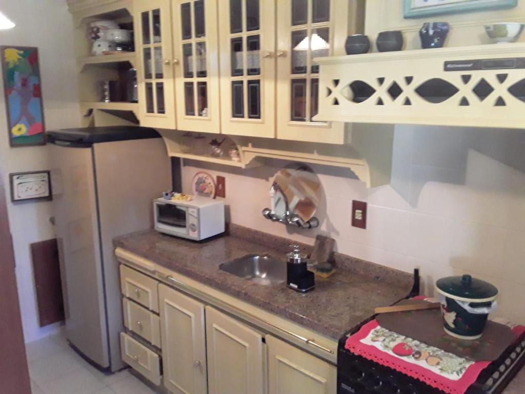 a kitchen with a sink and a refrigerator at Hospede-se no Coração de Gramado in Gramado