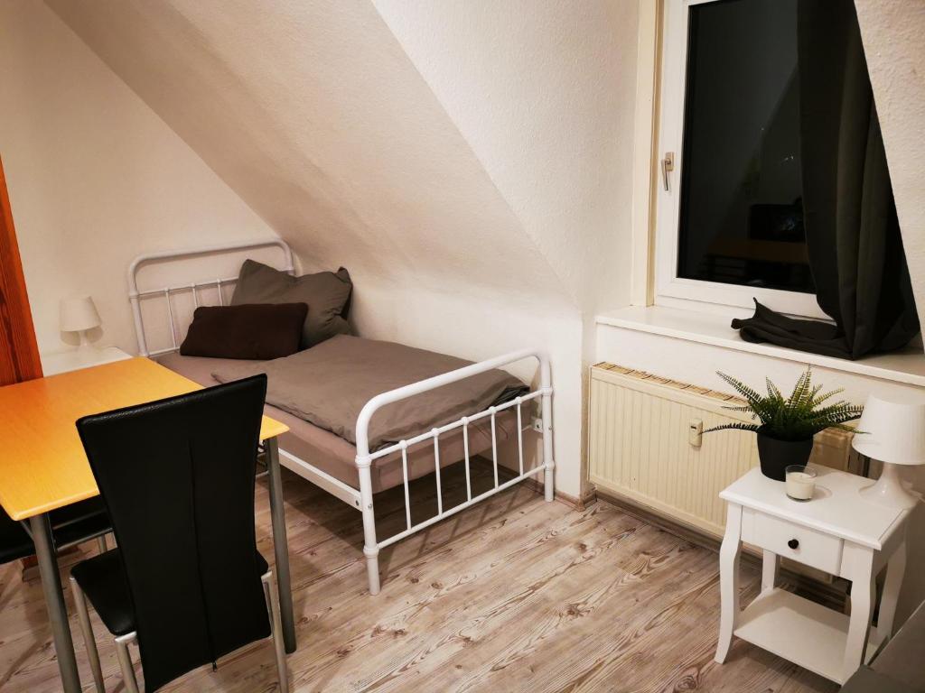 een kleine woonkamer met een tafel en een televisie bij Monteurzimmer Apartment Katlenburg-Lindau FairWohnen24 All-Inkl 24h Check-In in Katlenburg-Lindau