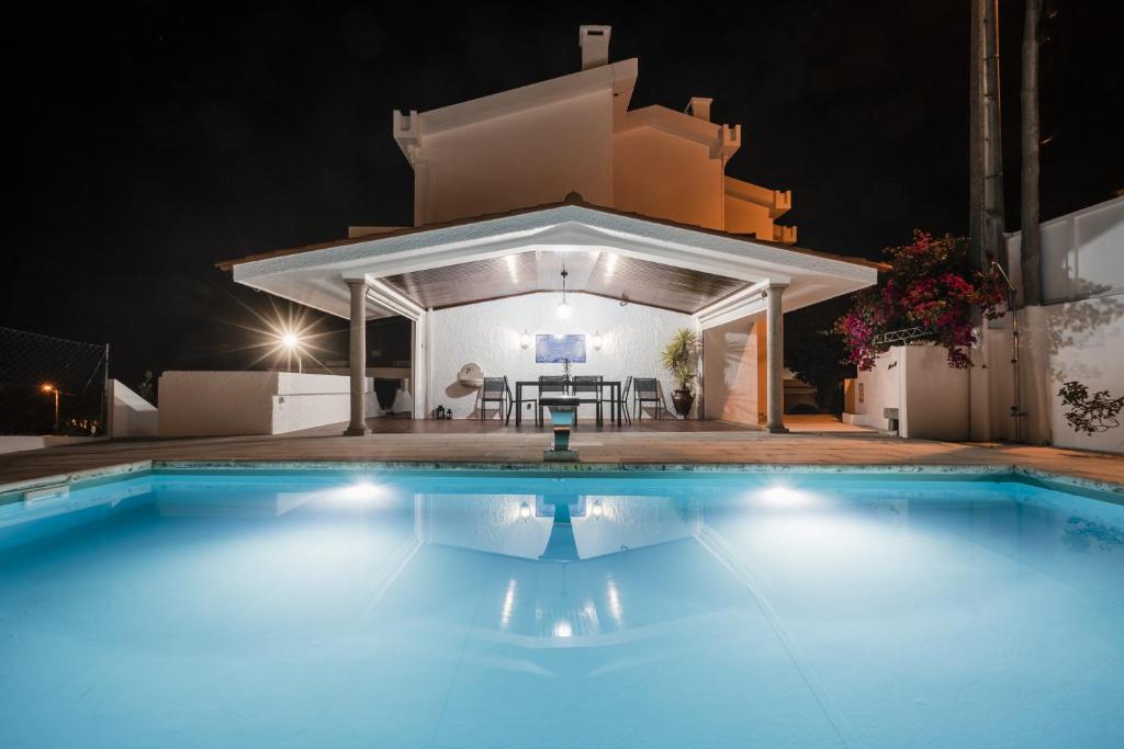 a swimming pool in front of a villa at night at Casa de Âncora in Vila Praia de Âncora