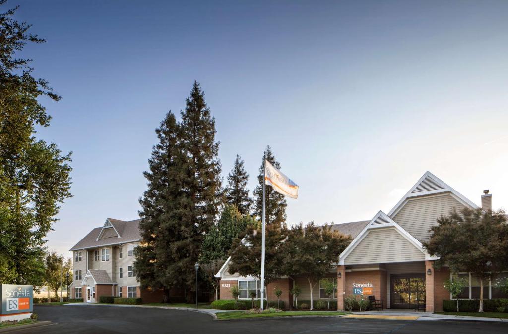 a view of the front of a hotel with a flag at Sonesta ES Suites Fresno in Fresno