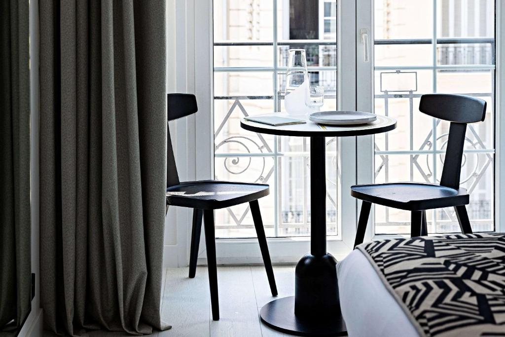 a room with two chairs and a table in front of a window at Le Riviera Collection, Signature Collection by Best Western in Nice