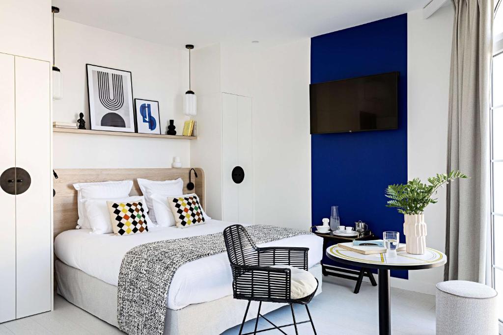 a bedroom with a bed with a blue accent wall at Le Riviera Collection, Signature Collection by Best Western in Nice
