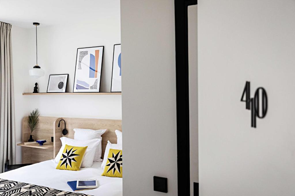 a bedroom with a bed with yellow and white pillows at Le Riviera Collection, Signature Collection by Best Western in Nice