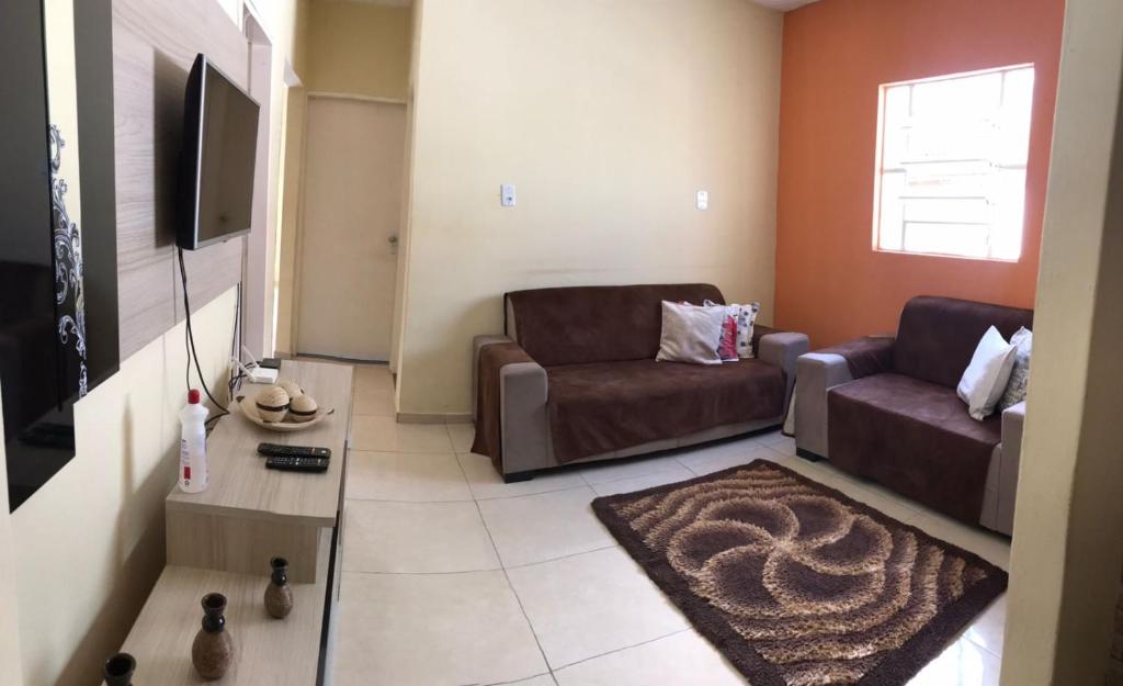 een woonkamer met 2 banken en een televisie bij Nosso aconchego in Piranhas