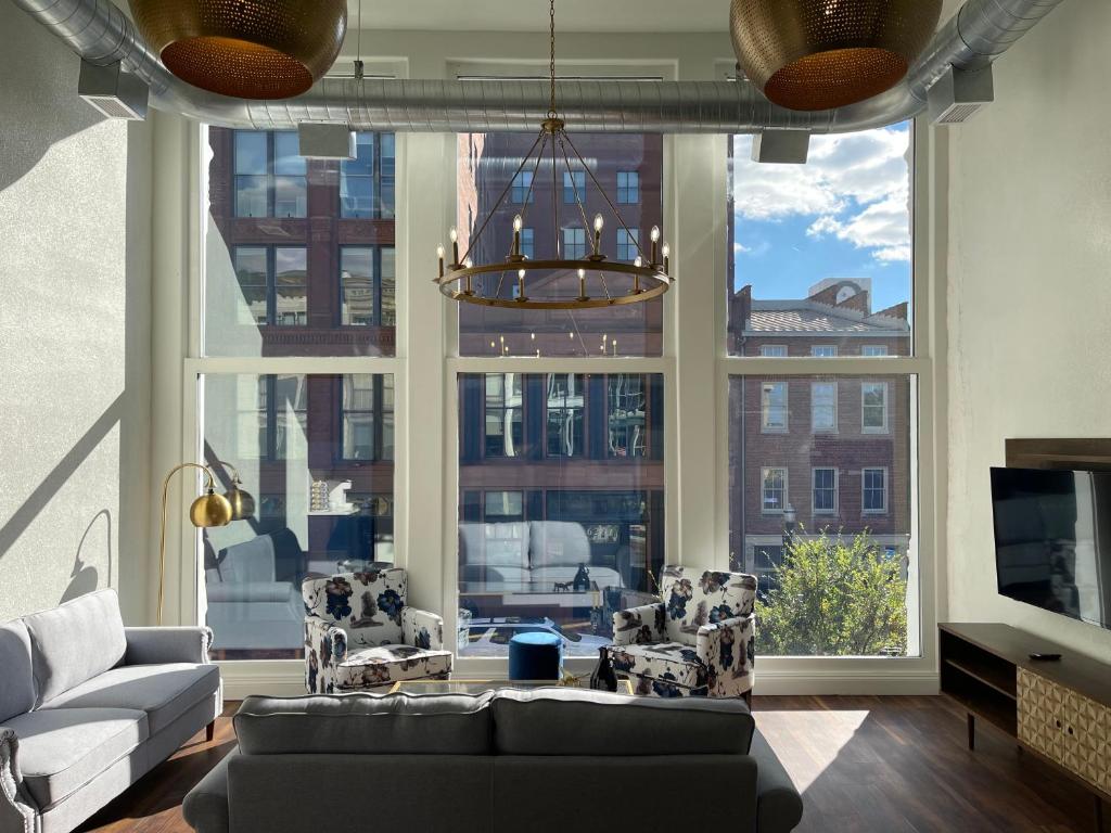 ein Wohnzimmer mit einem Sofa und einem großen Fenster in der Unterkunft Gold Suite by Hollyhock- Executive-Level Living in Louisville
