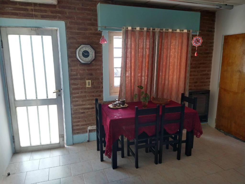 a dining room with a red table and chairs at Departamentos Fuentes in Cipolletti