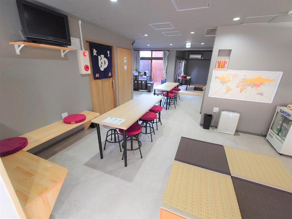 a classroom with tables and chairs and a large screen at Stay Inn KOTO in Kyoto