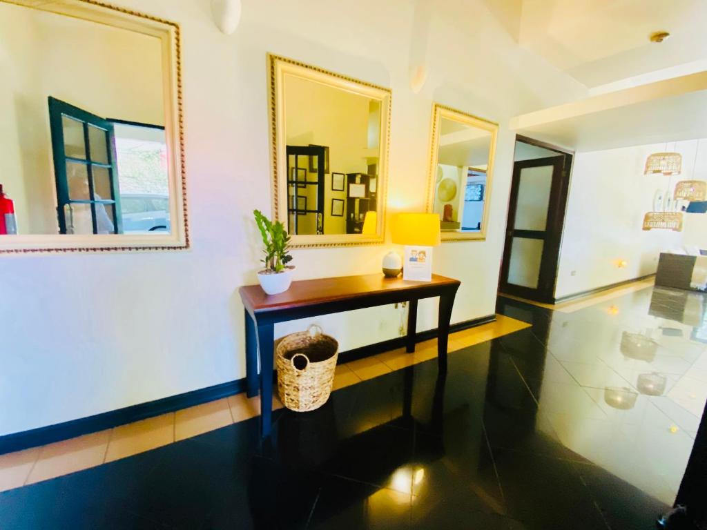 a room with a table and a mirror at Hotel Mango Airport in Alajuela