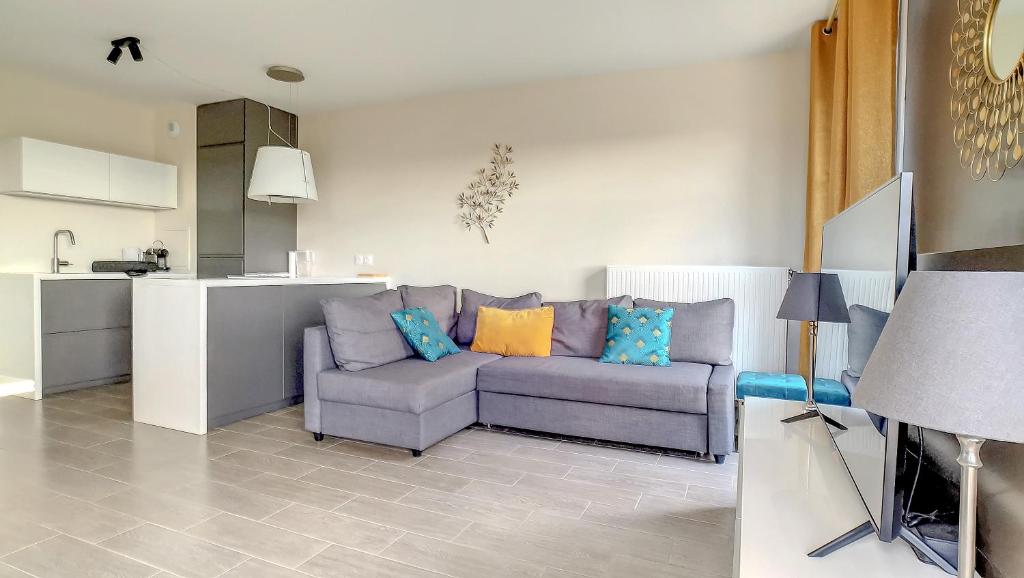 un salon avec un canapé et une cuisine dans l'établissement T3 Riviera Apartment Near Disneyland Paris, à Chessy