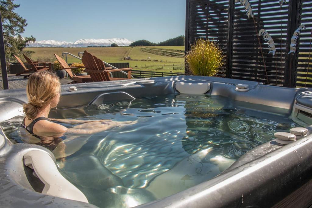 a woman is sitting in a jacuzzi tub at Shearvue Farmstay with Optional Free Farm Experience at 5pm in Fairlie