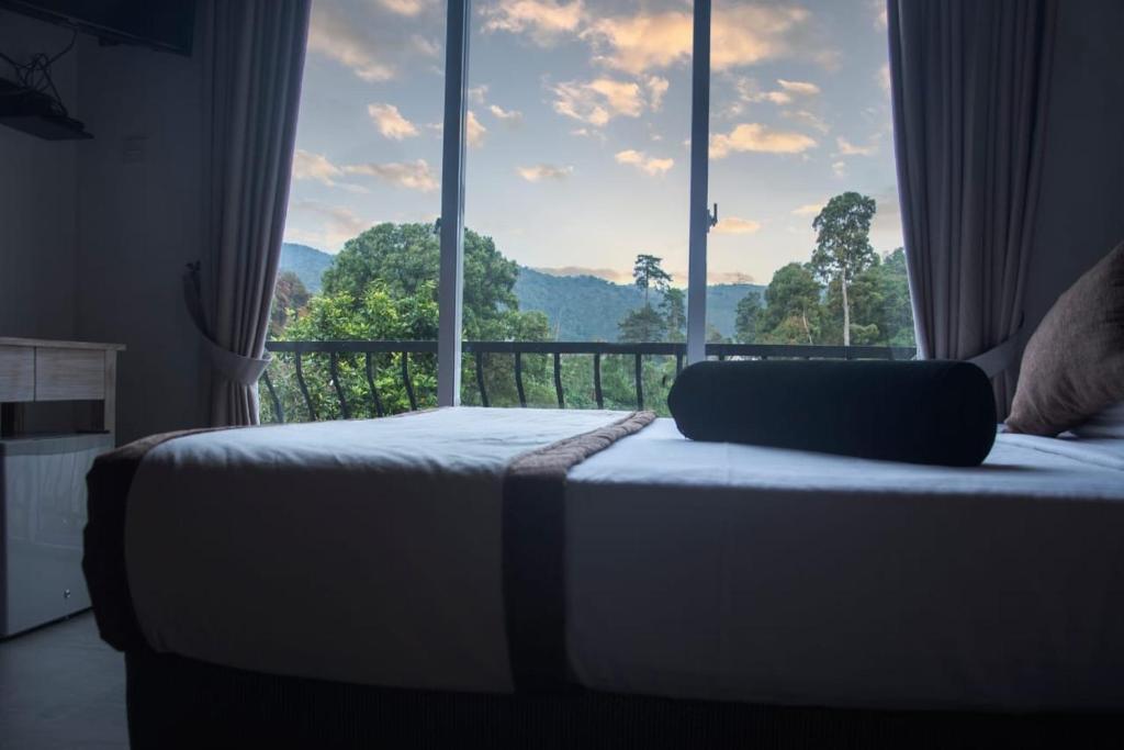 a bed in a bedroom with a large window at THE EDGWARE in Nuwara Eliya