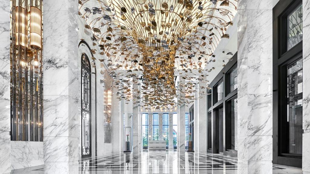 a hallway with a large chandelier in a building at The Langham, Jakarta in Jakarta