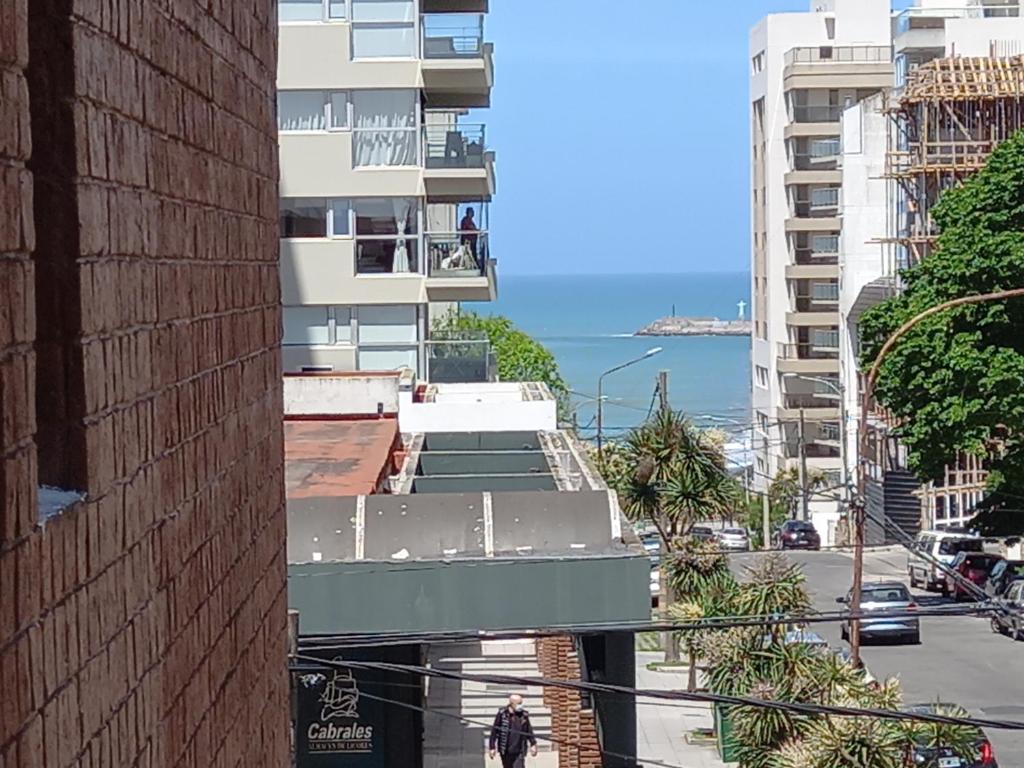 una persona che cammina lungo una strada accanto a un edificio di 2 ambientes en Playa Grande Matheu y Alem a Mar del Plata