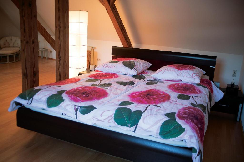 ein Bett mit rosa Rosen darauf in einem Schlafzimmer in der Unterkunft Stadthaus Sinfonia in Baden-Baden