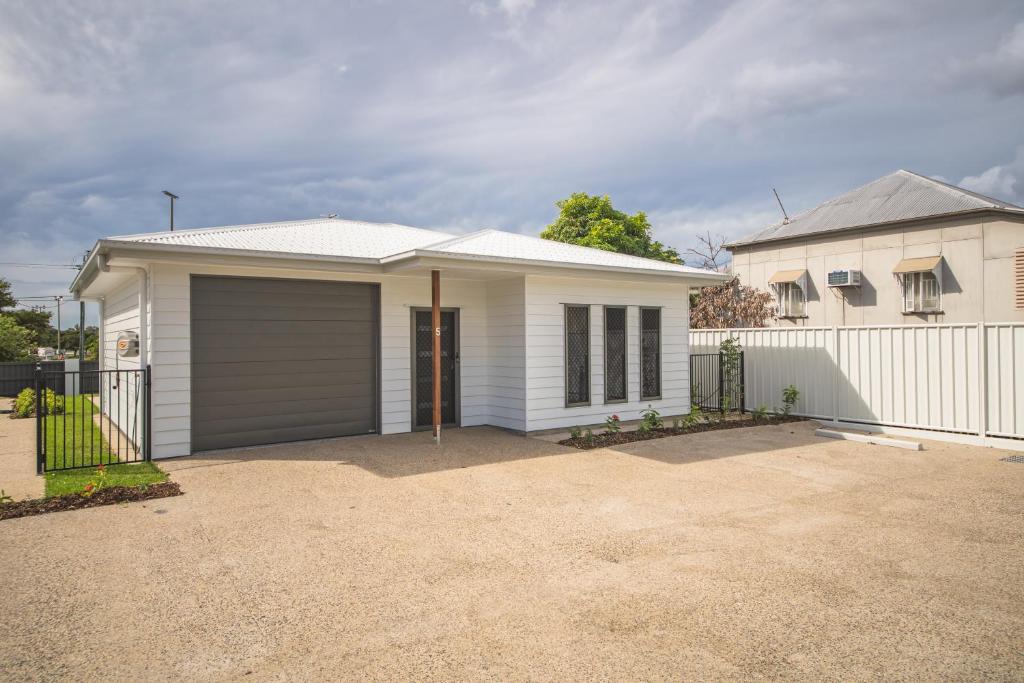 a white house with a garage in a driveway at Jardine Court Appartments in Rockhampton