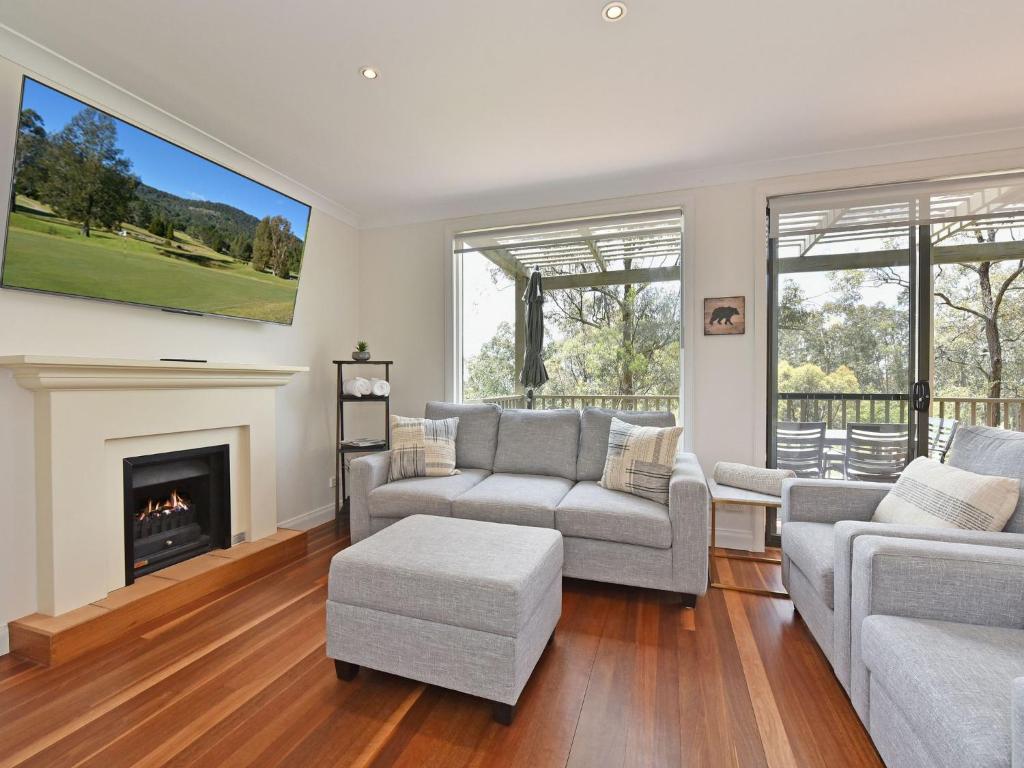 a living room with a couch and a fireplace at Villa 2br Heafy Lodge Villa located within Cypress Lakes Resort in Pokolbin