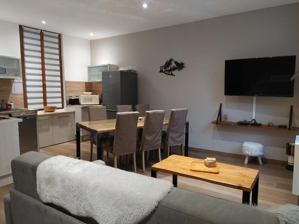 un salon avec un canapé et une table et une cuisine dans l'établissement Logement cosy 4/6 pers - quartier historique calme, à Cauterets