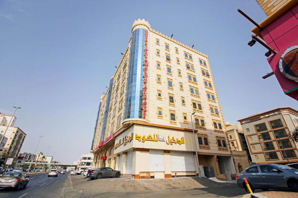 Al Tamayoz Al Raqi - Hiraa في جدة: مبنى طويل على شارع المدينة مع سيارات متوقفة