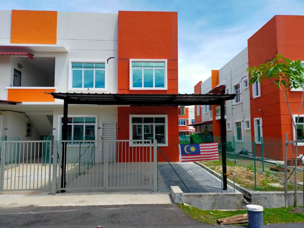 an orange and white house with an american flag at Zaara Homestay Krubong Alor Gajah Ayer Keroh Melaka in Malacca
