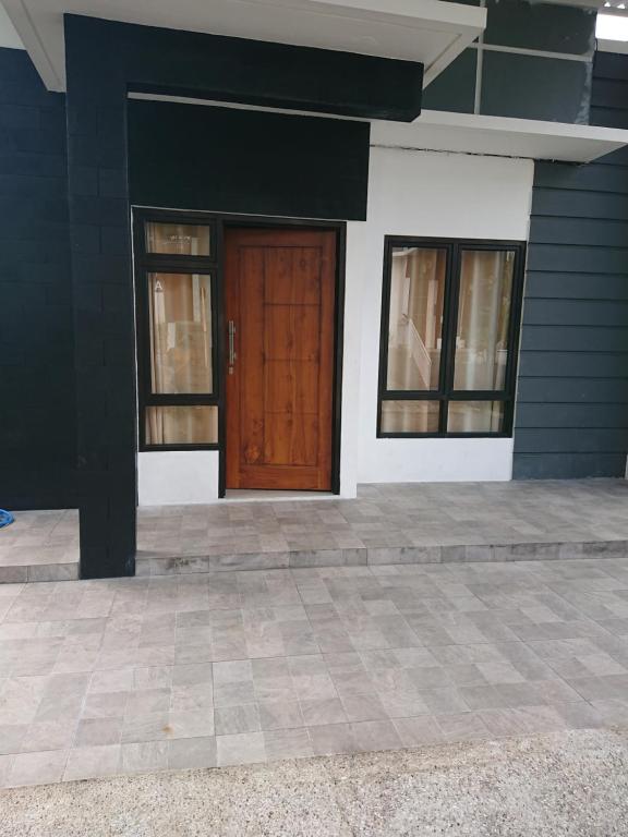 a house with a brown door and windows at Vila Bandungan in Bandungan