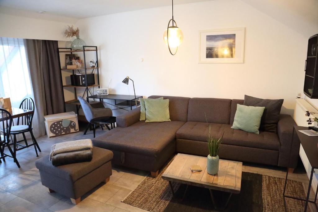 a living room with a brown couch and a table at Ferienwohnung Stöckel 2 in Cuxhaven
