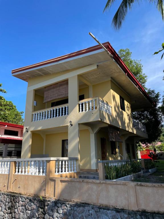 a house with a balcony in front of it at C - Side Inn in Mambajao