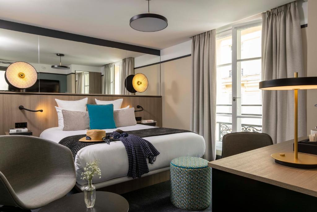 Cette chambre comprend un lit, une table et un bureau. dans l'établissement Hôtel Opéra Liège, à Paris
