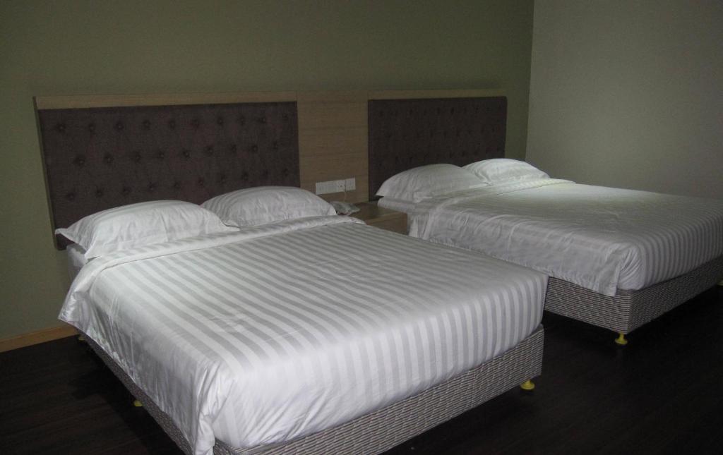 Postel nebo postele na pokoji v ubytování Seri Simanggang Hotel