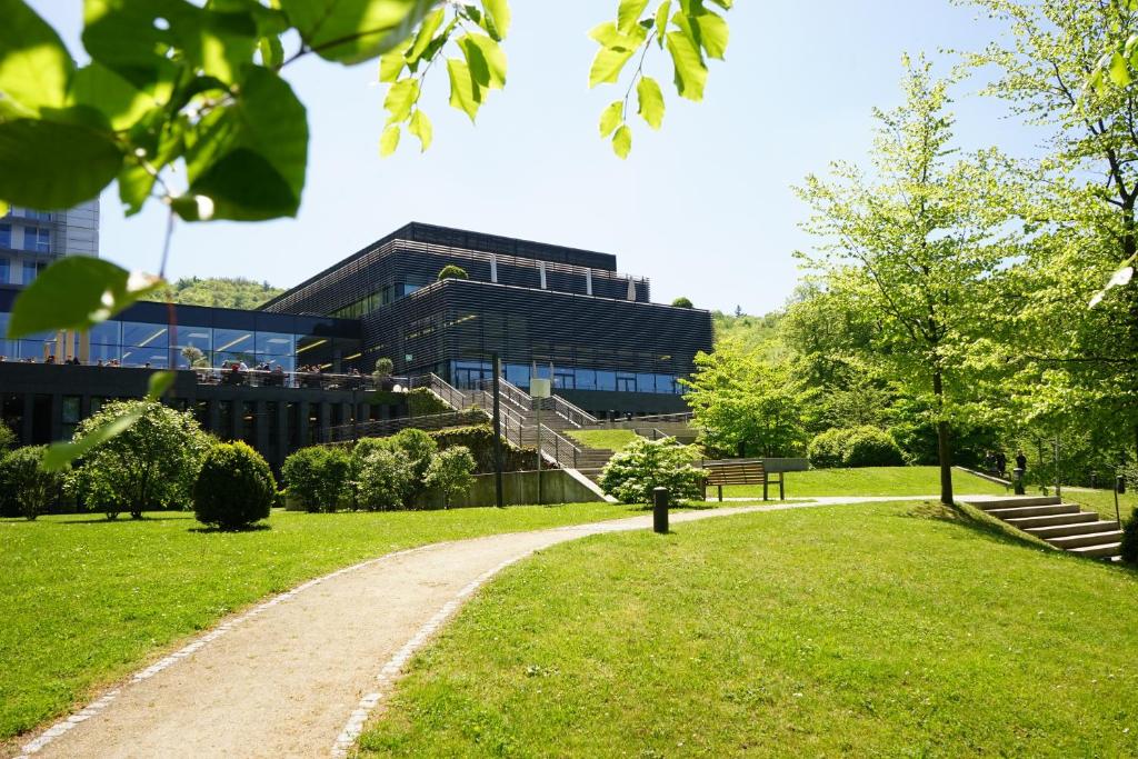 a building in a park with a path in front at Lufthansa Seeheim - More than a Conference Hotel in Seeheim-Jugenheim