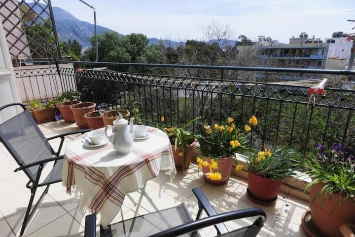 a table and chairs on a balcony with plants at "Sotiria Beta" apartment in Kalamata