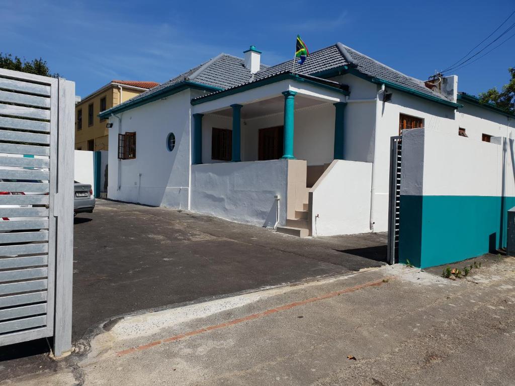 a white and blue house with a gate at Fama Lodge Single Rooms in Cape Town