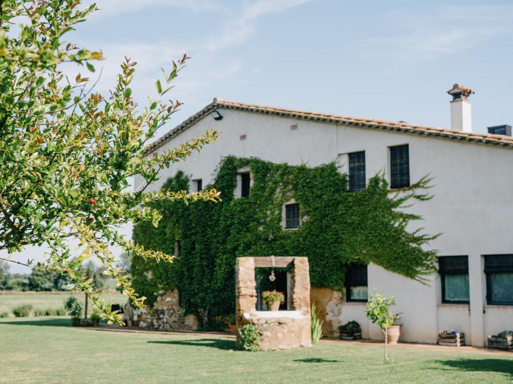 a white house with ivy growing on it at Can Serrà 1786 in Llagostera