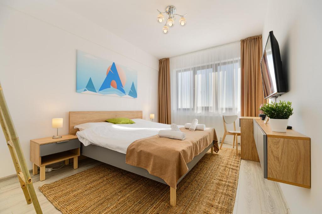 The Mountain Nest في براشوف: غرفة نوم بسرير ومكتب وتلفزيون