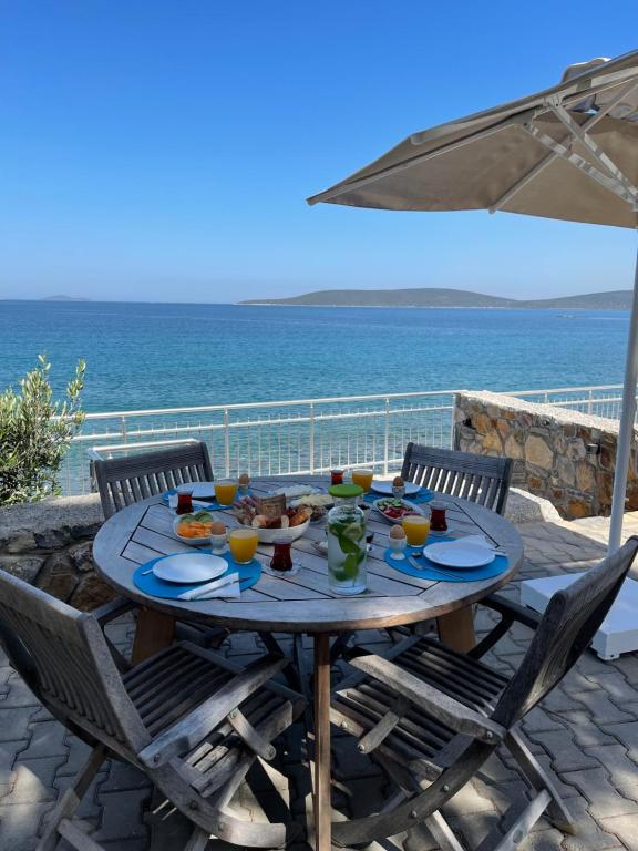 una mesa con comida y vistas al océano en Beach House With Direct Access to Private Beach Near Bodrum, en Çamlık