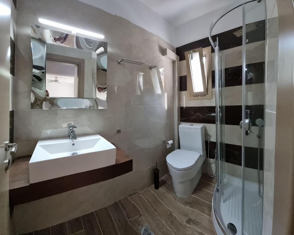 ein Badezimmer mit Waschbecken, Toilette und Dusche in der Unterkunft Skiathos Lagoterra Apartments in Skiathos-Stadt