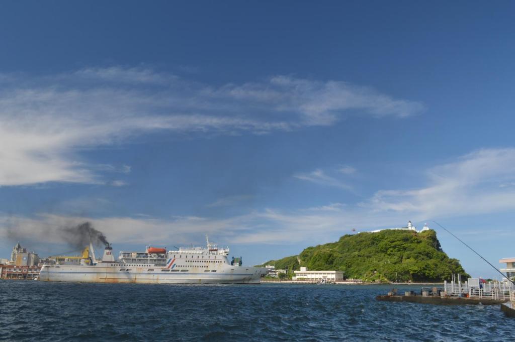 a cruise ship and an island in the water at Watermark Hotel - Sizihwan in Kaohsiung