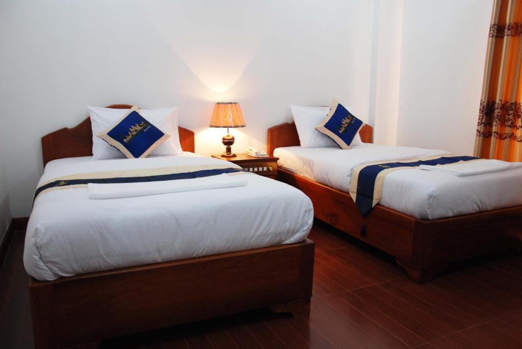 Postel nebo postele na pokoji v ubytování Emerald BB Battambang Hotel