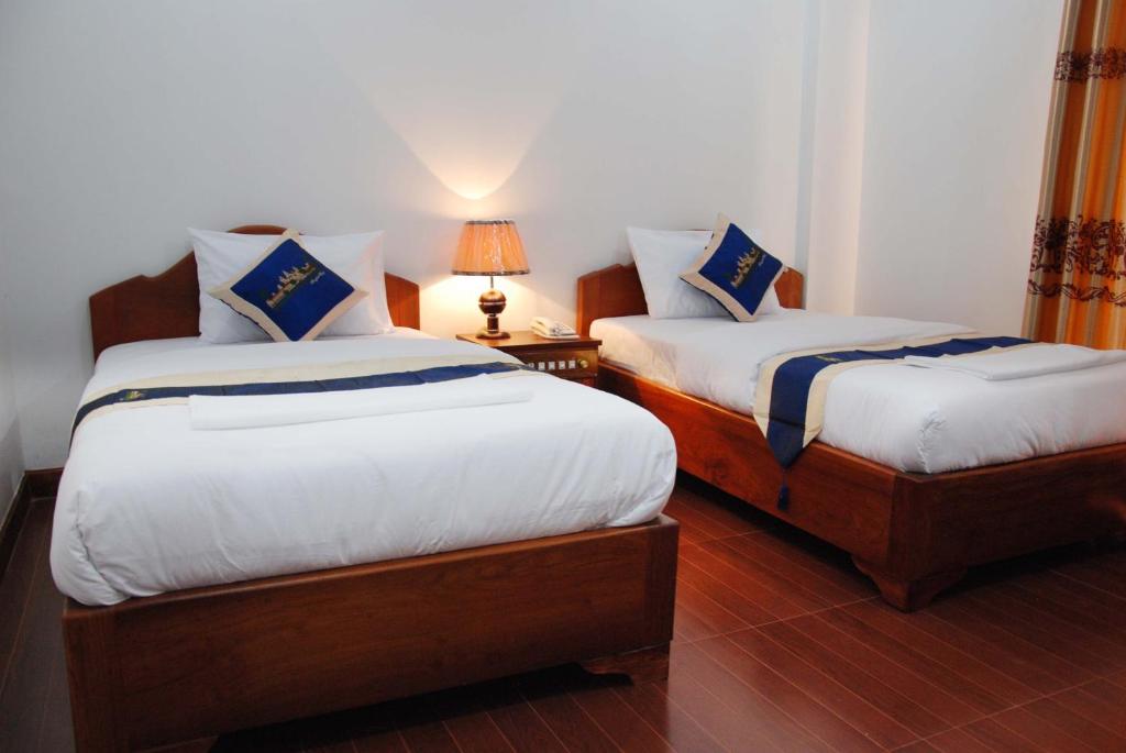 Postel nebo postele na pokoji v ubytování Emerald BB Battambang Hotel