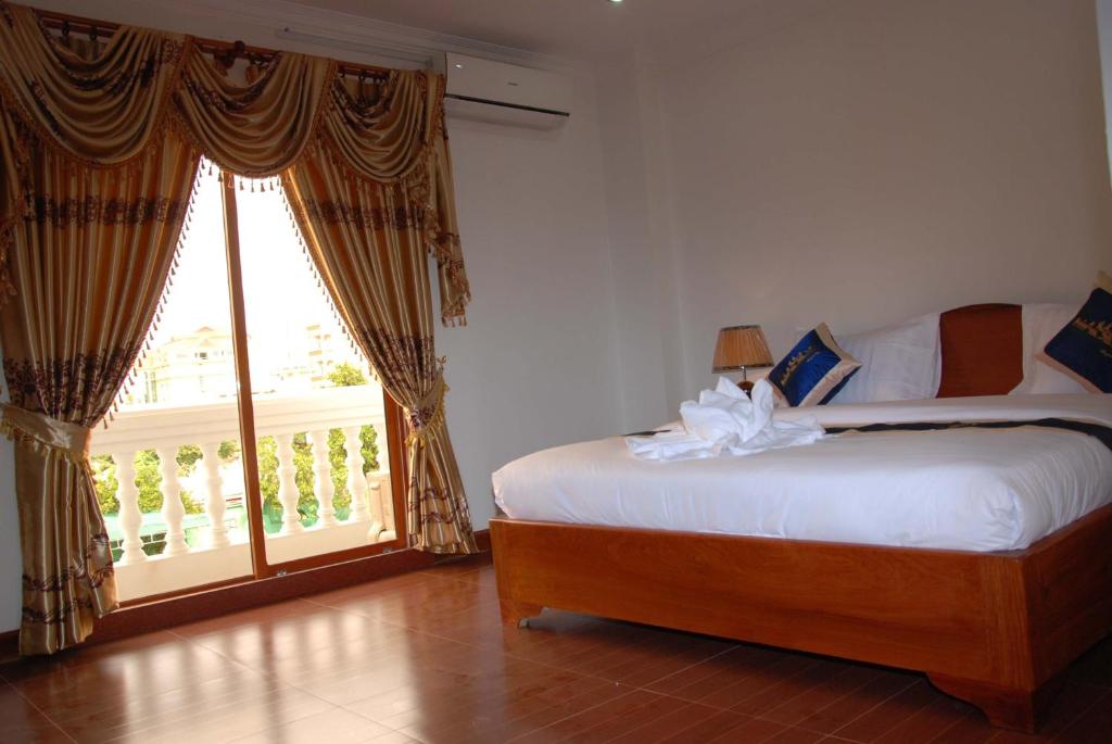 Postel nebo postele na pokoji v ubytování Emerald BB Battambang Hotel