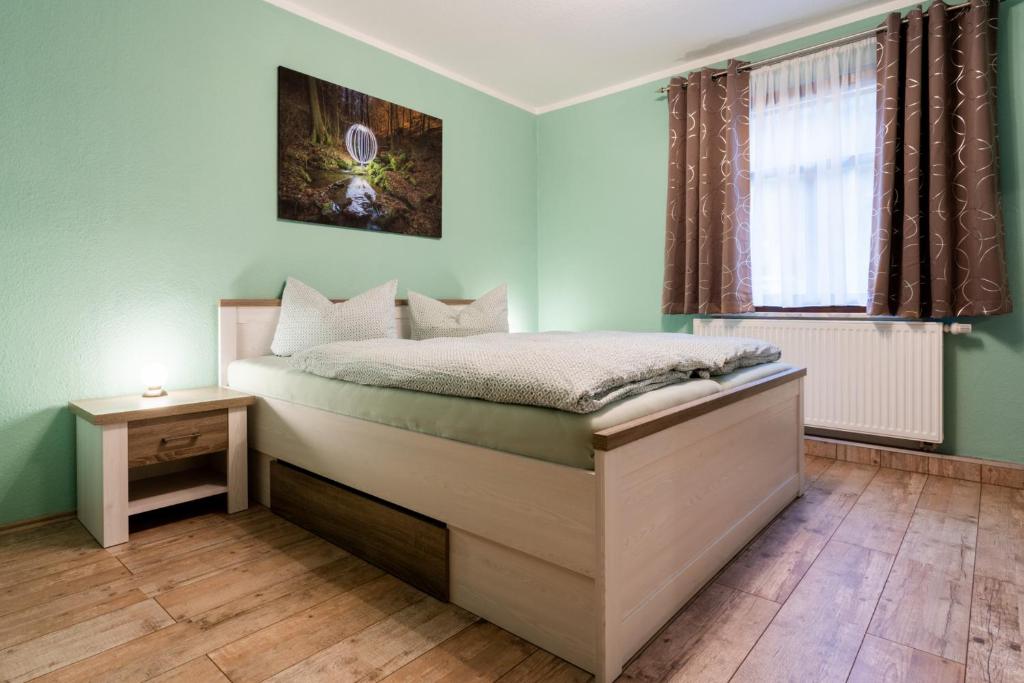 a bedroom with a bed and a window at Ferienwohnung Julia Unterweißbach in Unterweißbach