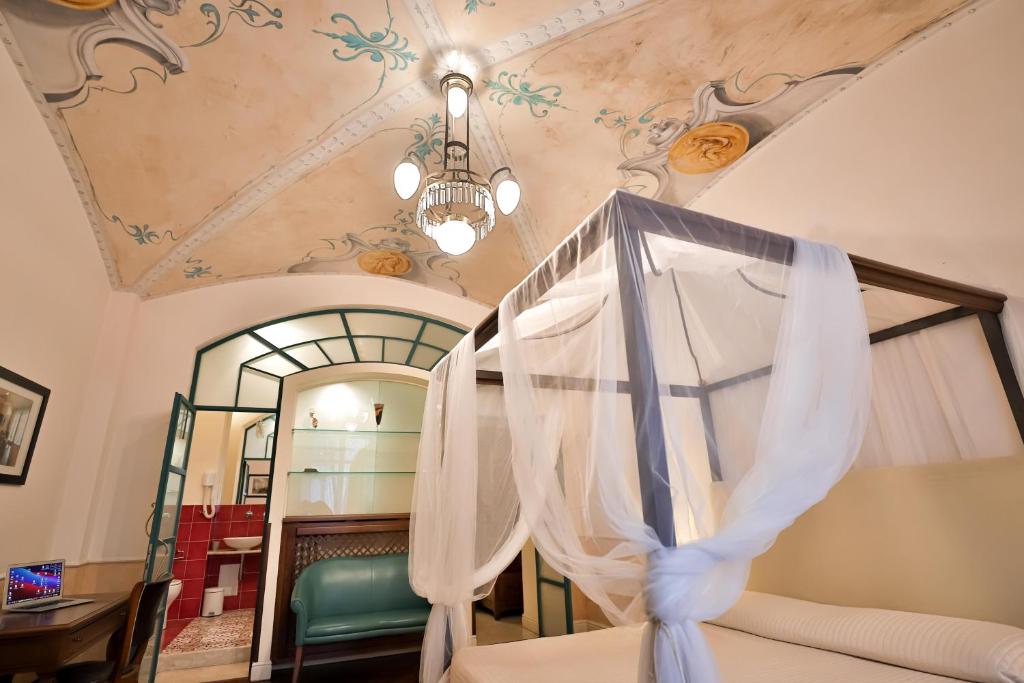 1 dormitorio con cama con dosel y espejo en Kriò Suite, en Salerno