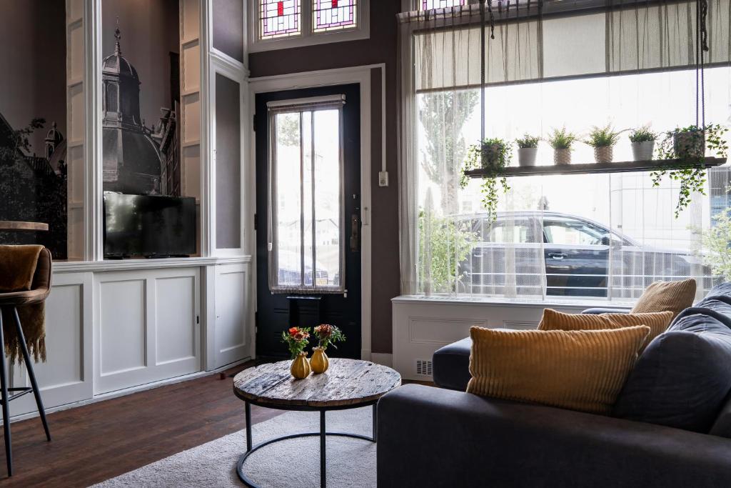 een woonkamer met een bank en een tafel bij Logement De drie stokvisschen in Middelburg
